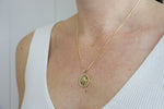 Load image into Gallery viewer, Model wearing AW Boutique&#39;s gold filled 18 inch box chain with a vintage looking Hamsa coin pendant. The Hamsa has small inscriptions and an evil eye on the hand. Pendant has rope effect edging. Part of Protection collection. Gold filled jewellery.
