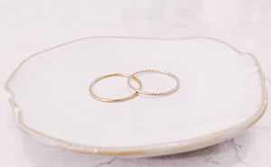 Plain Stacker & Sparkle stacker rings laying on a jewellery trinket dish by lady startup Australian jewellery label, AW Boutique.