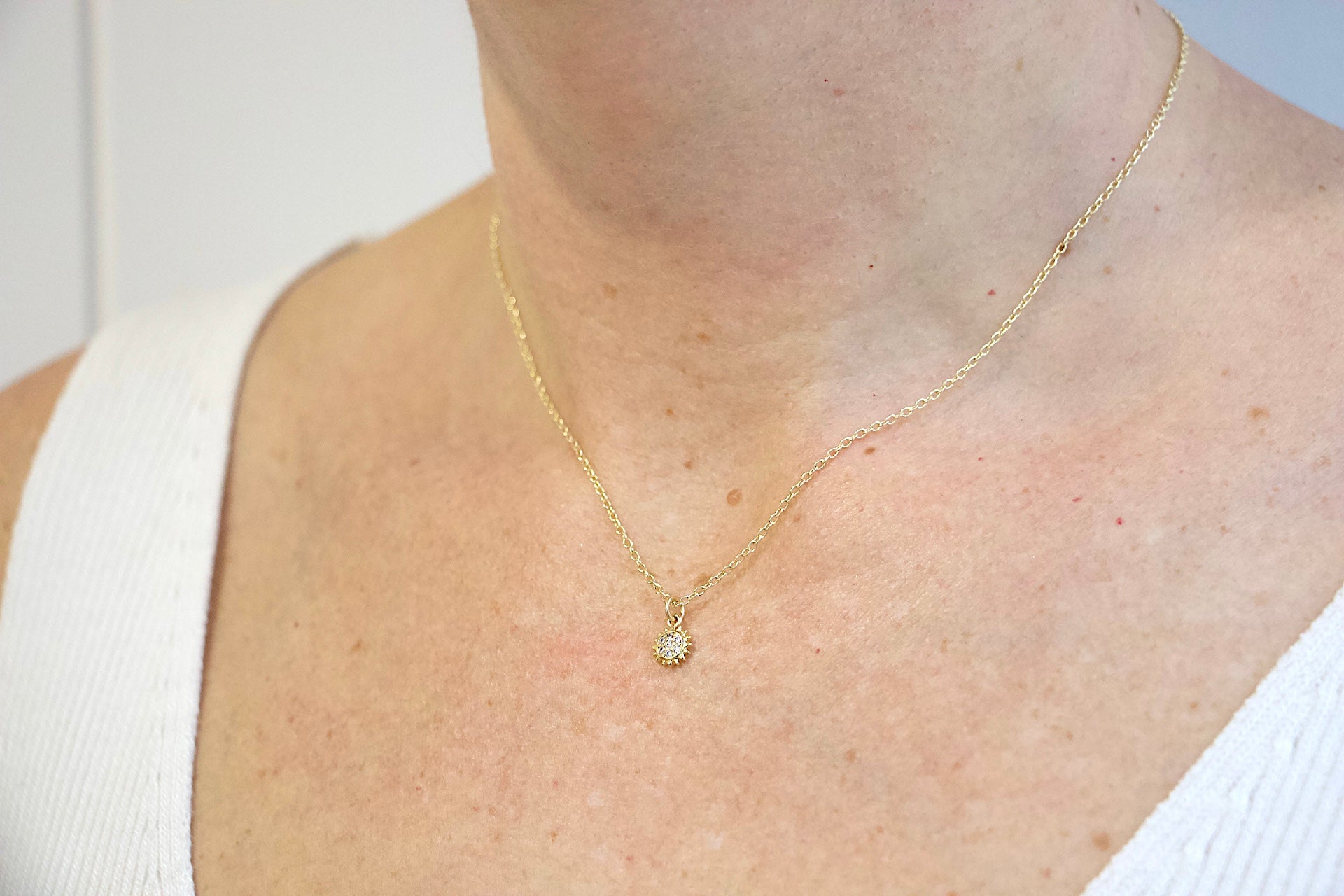 Model wearing AW Boutique's gold filled 16 inch dainty necklace with a mini Sun charm pendant. Part of Celestial collection. Gold filled jewellery. 
