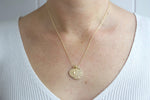 Load image into Gallery viewer, Model wearing gold filled zodiac star sign coin charm necklace. Australian jewellery brand AW Boutique. Part of the Celestial Collection. Necklace option shown is Taurus.
