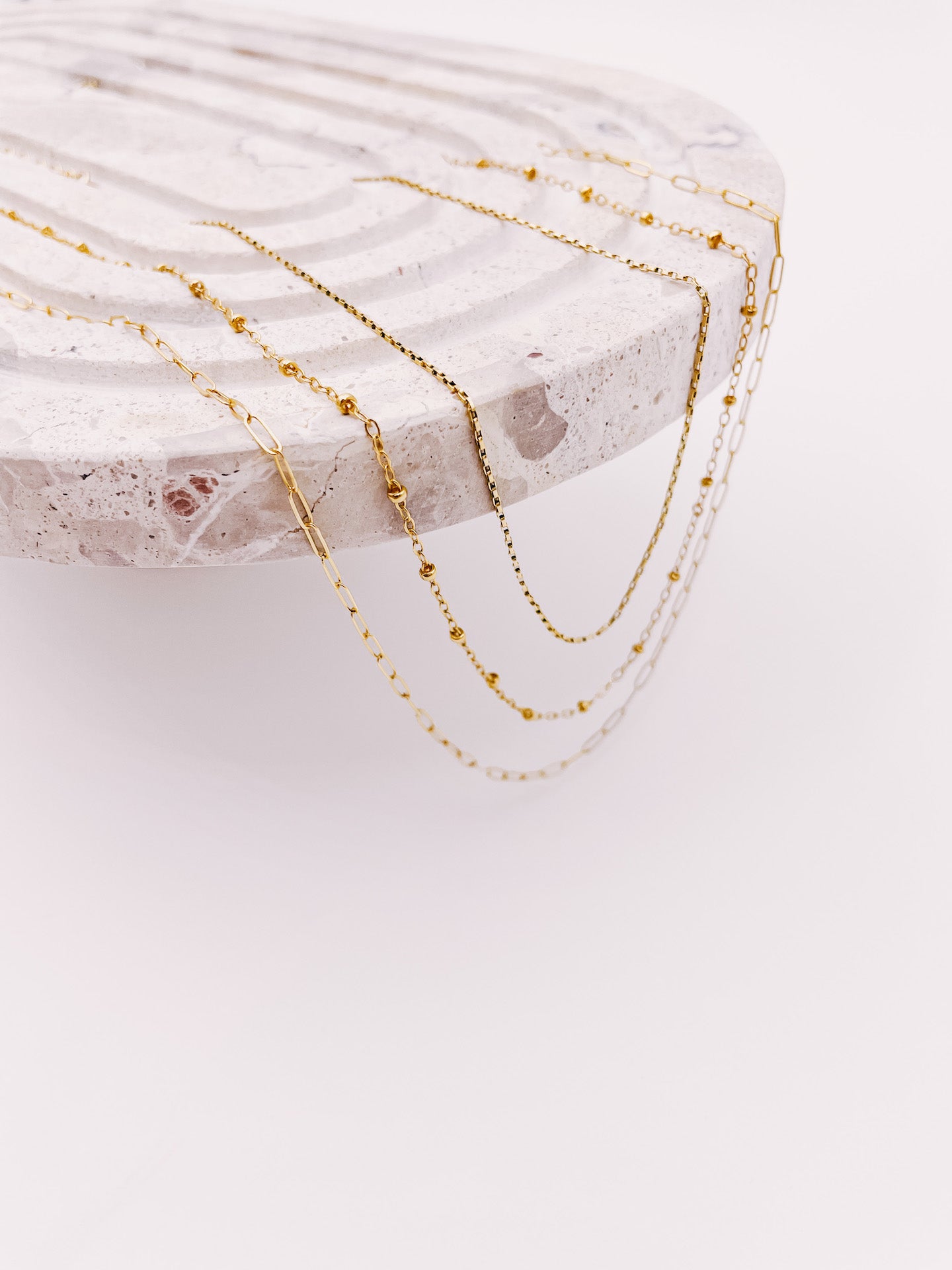 3 layering chains draped hanging off end of tray from AW Boutique gold filled jewellery.