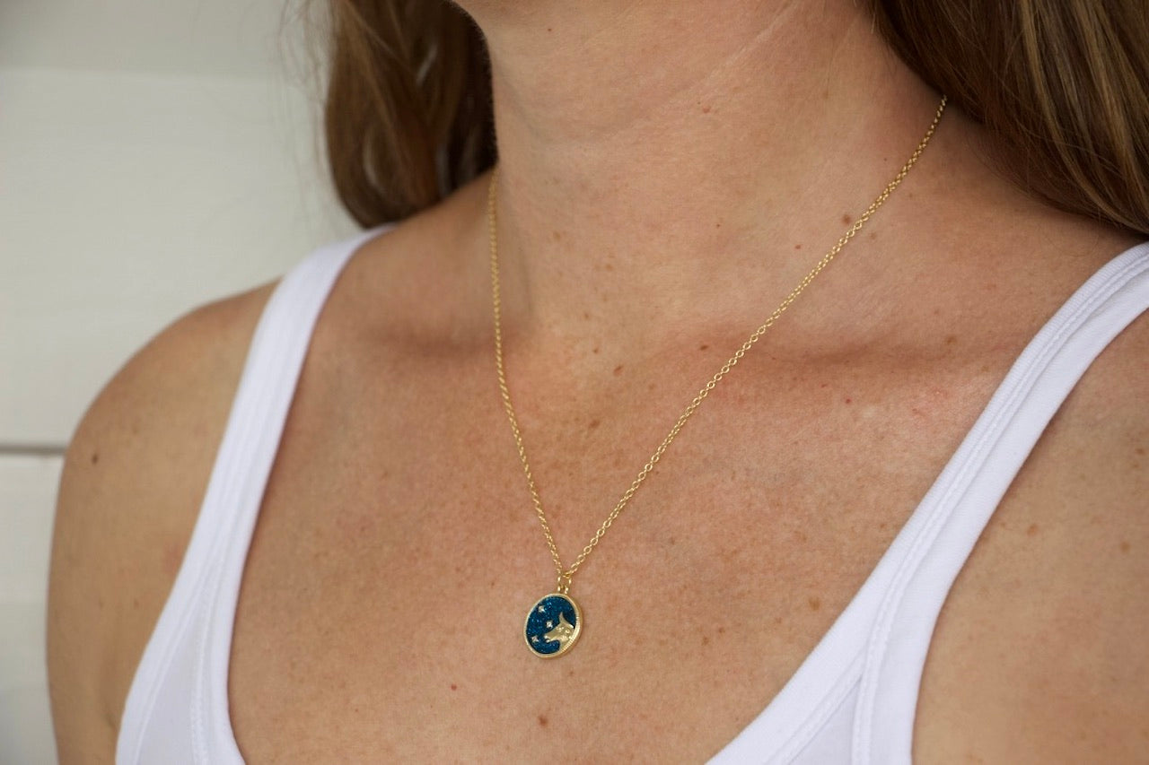 Model wearing AW Boutique's Zodiac Astro Coin is a dainty pendant full of sparkle and shine.  This piece adds a pop of colour to your everyday wear and at 18 inches is a great length to mix and layer your other chains with.  Proudly wear either your own star sign or the star sign of a loved one close to your heart.  Zodiac shown is Taurus.