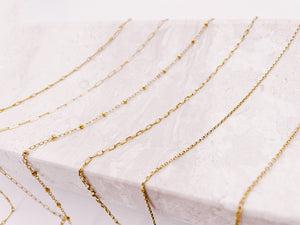 6 layering chains draped on tray from AW Boutique gold filled jewellery.