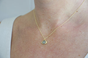 Model wearing AW Boutique gold filled jewellery. Evil Eye pendant charm on a dainty 16 inch fine cable necklace chain. Part of the Protection collection.