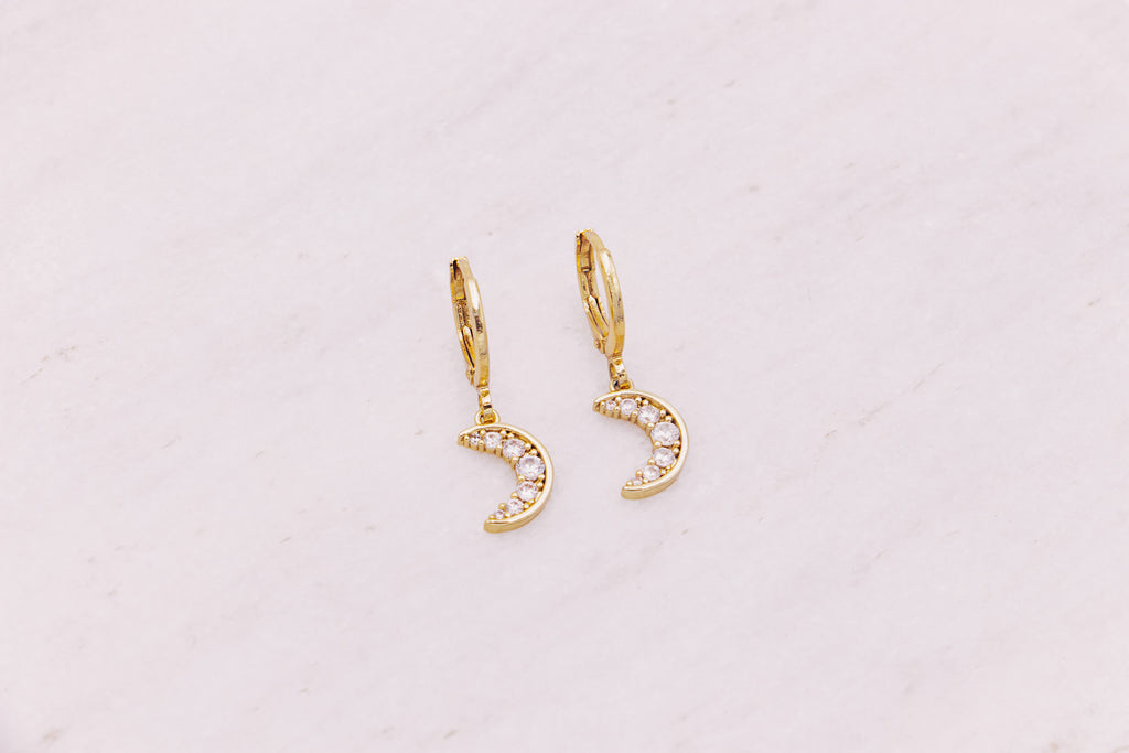 Mini crescent moon shaped charm hanging from gold filled huggie earrings.  Celestial jewellery.