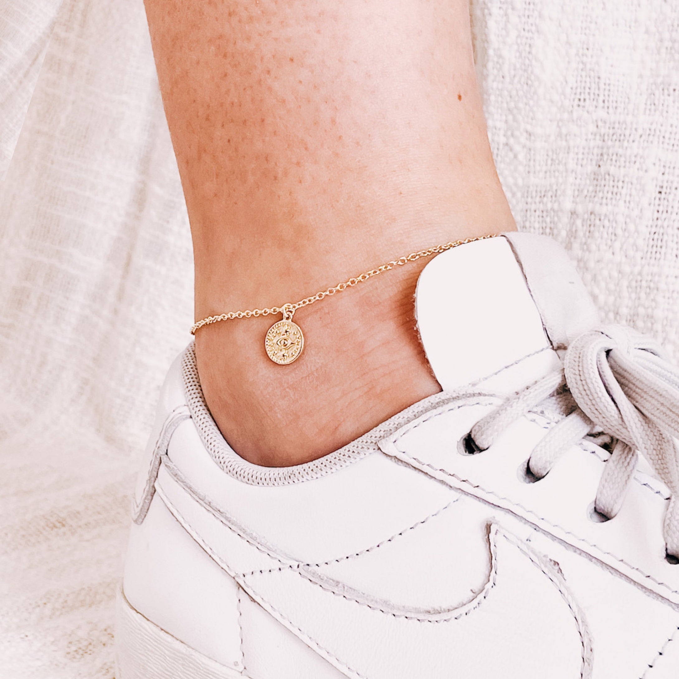 Model wearing AW Boutique's Mini Evil Eye Gold Coin Anklet.